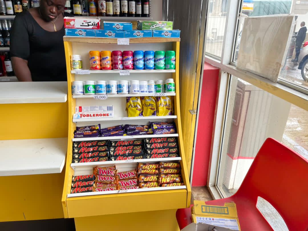 Chocolate and chewing gum displayed on a freestanding unit beside a retail counter